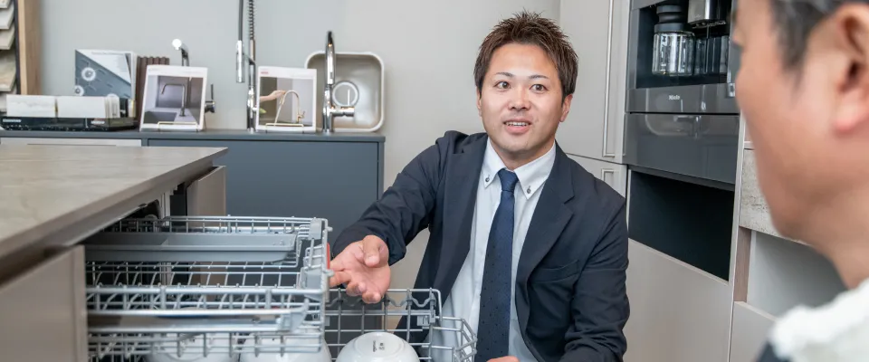 食洗機の中を見せるスタッフの写真
