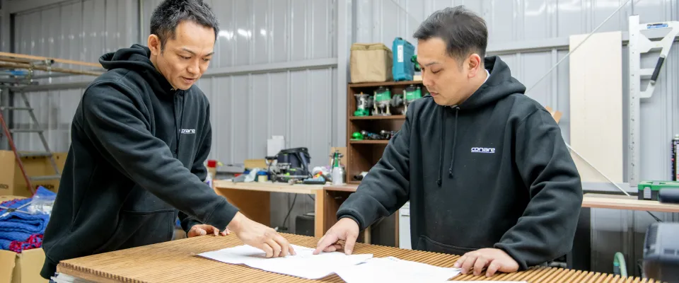 図面を指さしながら話し合うスタッフの写真