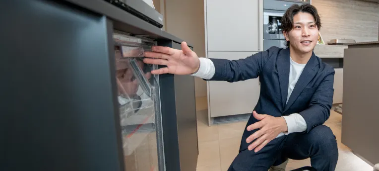 食洗機を見せるスタッフの写真