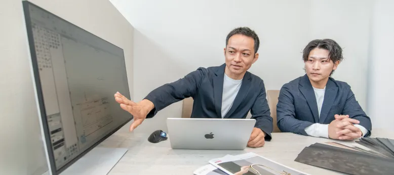 PCの前でお見積りの説明をするスタッフ