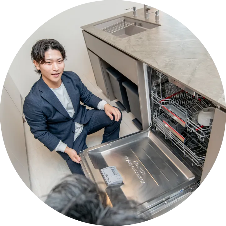 食洗機の中を見せるスタッフの写真ん
