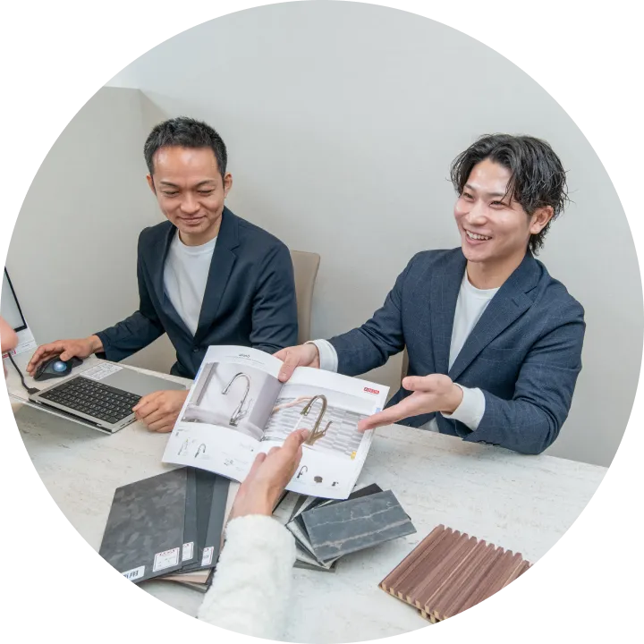 パンフレットを見せて顧客に説明をするスタッフの写真