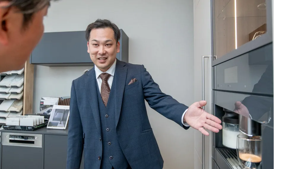 コーヒーメーカーにコーヒーを入れる所を解説しているスタッフ