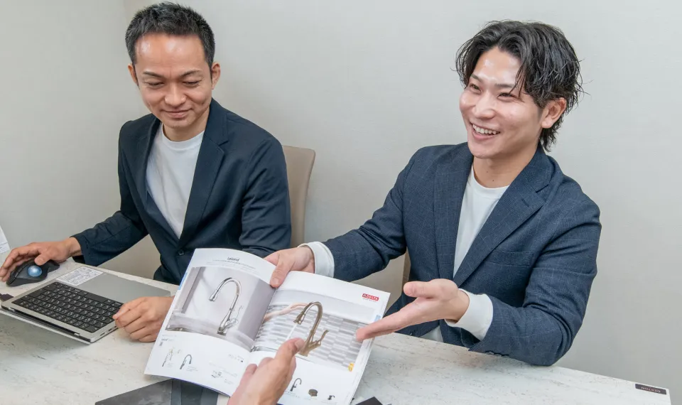 パンフレットを見せて顧客に説明をするスタッフの写真