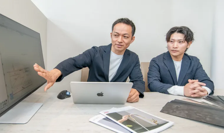 PCの前でお見積りの説明をするスタッフ