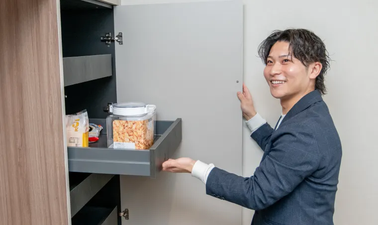 キッチンの棚から物を取り出しているスタッフの写真