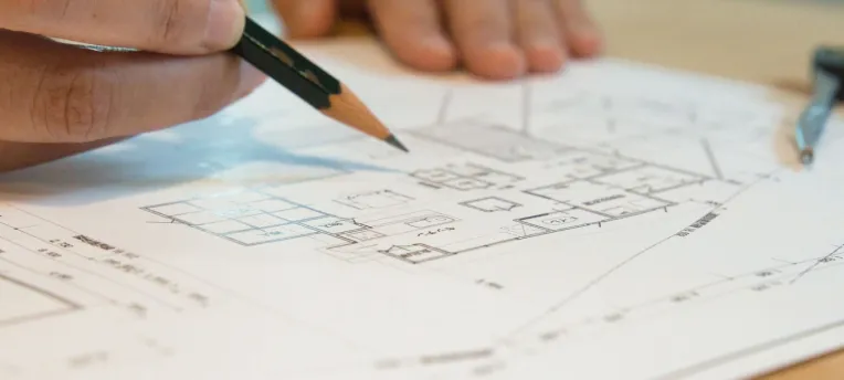 図面に鉛筆でものを描いている写真