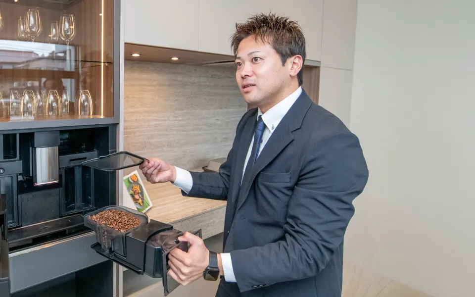 コーヒーメーカーについてプレゼンするスタッフ